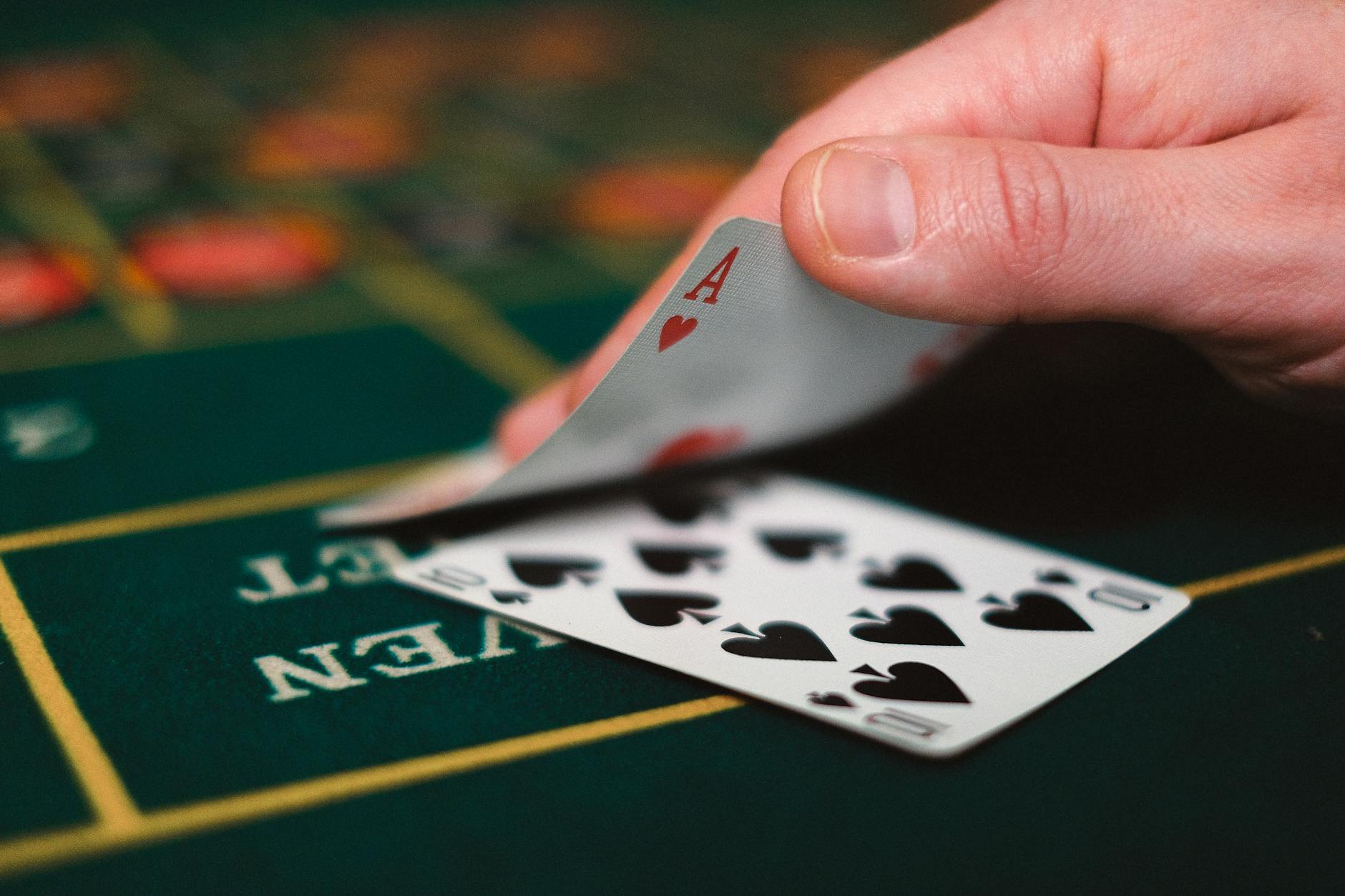 Người chơi blackjack cầm bài bên cạnh chip trên bàn casino