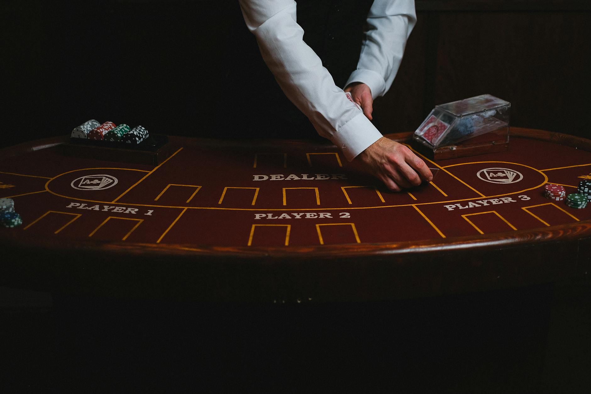 Dealer chia bài tại bàn casino trực tiếp trong studio hiện đại